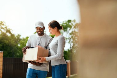 Paketi teslim. Teslimatçı kutusu kadına teslim