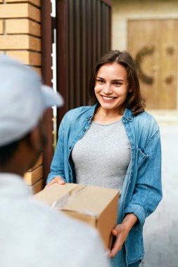 Teslimat hizmeti. Evde kadına paket teslim kurye.