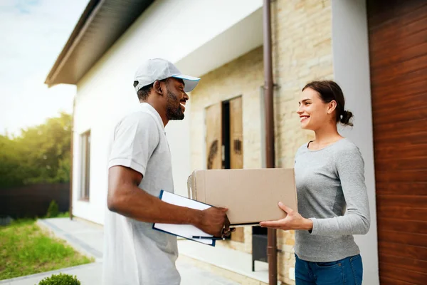 Consegna corriere. Consegnare pacchetto uomo alla donna a casa — Foto Stock