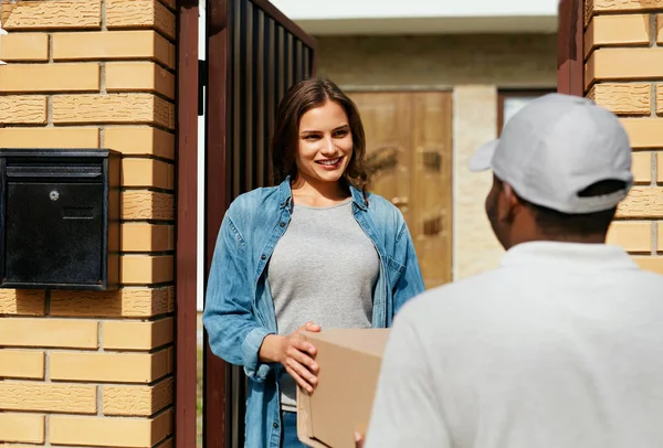 Teslimat hizmeti. Evde kadına paket teslim kurye.