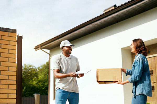 Courier Delivery. Man Delivering Package To Woman At Home