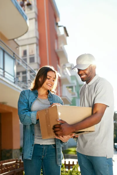 Entrega do pacote. homem Courier entregando caixa para mulher em casa — Fotografia de Stock