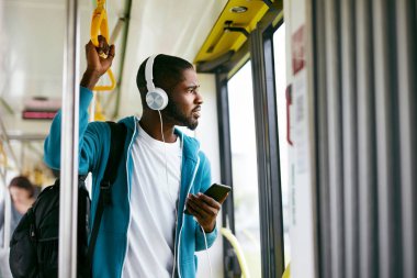 Telefonu kullanarak, tren seyahat müzik dinleme adam