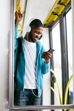 Telefonu kullanarak, tren seyahat müzik dinleme adam