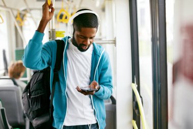 Telefonu kullanarak, tren seyahat müzik dinleme adam