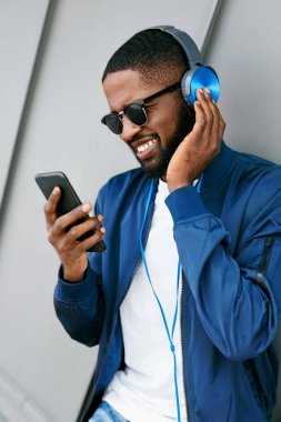 Müzik dinle. Adam kulaklık ve telefon moda giysileri 