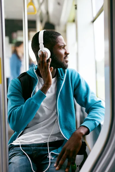Muž ve sluchátkách poslouchat hudbu v dopravě — Stock fotografie
