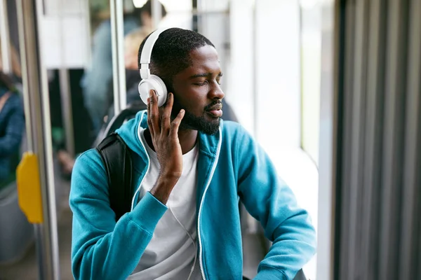 Homem em fones de ouvido ouvir música equitação no transporte — Fotografia de Stock