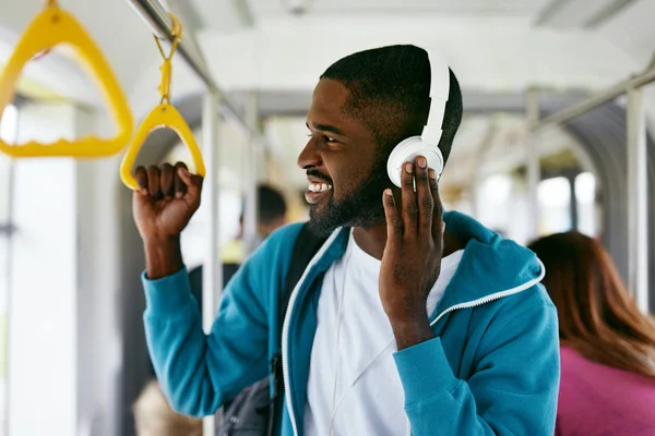 Muž ve sluchátkách poslouchat hudbu v dopravě — Stock fotografie