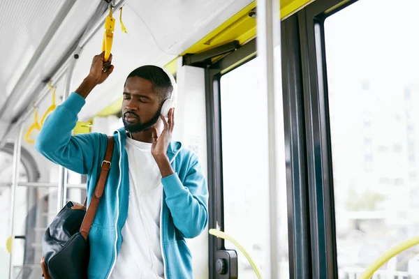 Hombre en auriculares escuchando música montando en el transporte — Foto de Stock