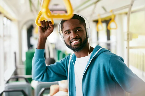 Mannen i hörlurar lyssna musik ridning i Transport — Stockfoto