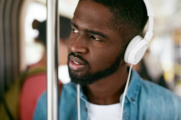 Musik hören. Schwarzer Mann mit Kopfhörern fährt in Bus — Stockfoto