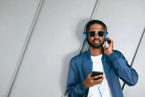 Homem ouvindo música em fones de ouvido no telefone na rua . — Fotografia de Stock