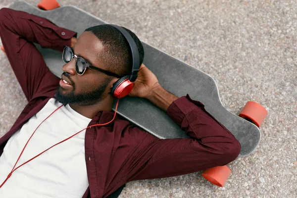Mode. Schwarzer hört Musik über Kopfhörer auf der Straße — Stockfoto