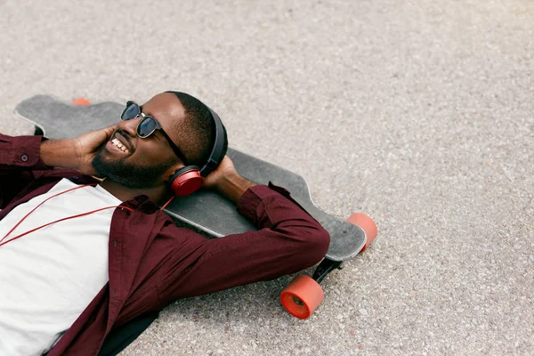 Fashion. Black Man Listening Music In Headphones On Street