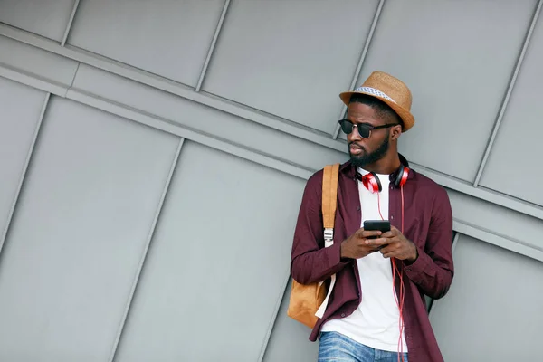 Schöner schwarzer Mann in modischer Kleidung mit Handy auf der Straße — Stockfoto