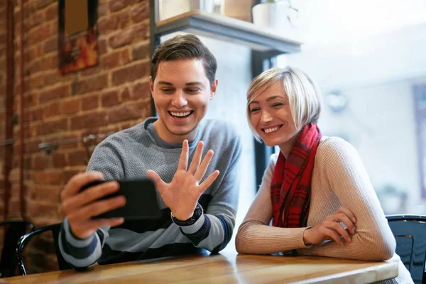 Casal usando no telefone no café para chamadas de vídeo ou tirar fotos — Fotografia de Stock