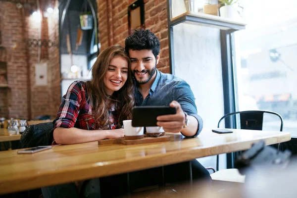 Paar gebruiken op telefoon In Cafe voor Video bellen of foto 's — Stockfoto