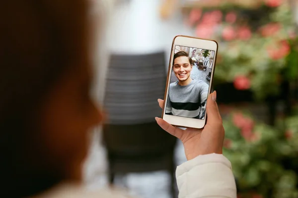 Videoanruf am Telefon. Nahaufnahme mit Telefon und Gesicht auf dem Bildschirm — Stockfoto