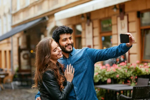 Paar benutzt Handy auf der Straße, macht Fotos oder Videoanrufe — Stockfoto