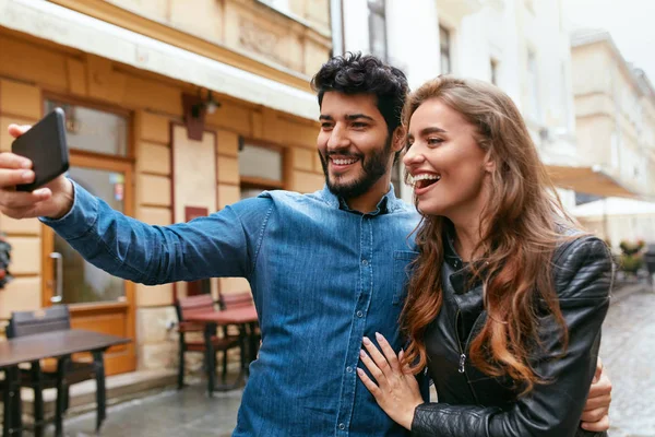 Paar benutzt Handy auf der Straße, macht Fotos oder Videoanrufe — Stockfoto