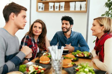 İnsanlar akşam yemeği birlikte Cafe tablo sahip.