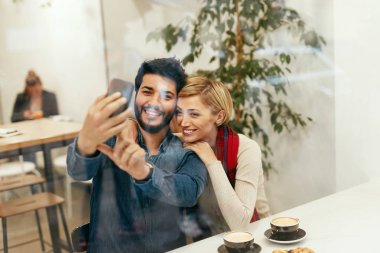 Mutlu insanlar istimal telefon fotoğraf çekmek Cafe,