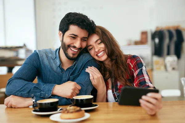 Glückliche Menschen, die im Café telefonieren und Fotos machen — Stockfoto