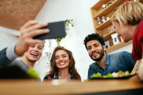 Menschen beim Abendessen beim Fotografieren am Telefon. Videoanruf von Freunden — Stockfoto