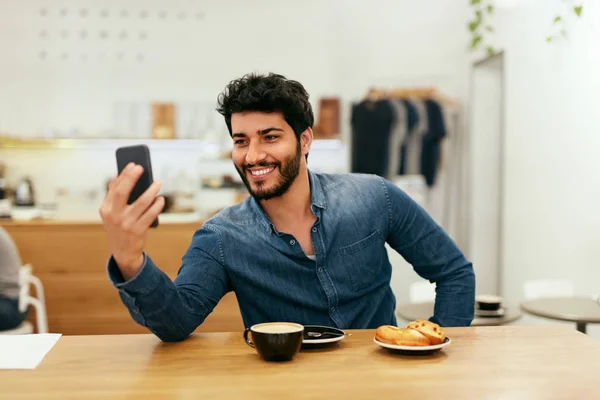 Homem feliz usando telefone no local do café — Fotografia de Stock