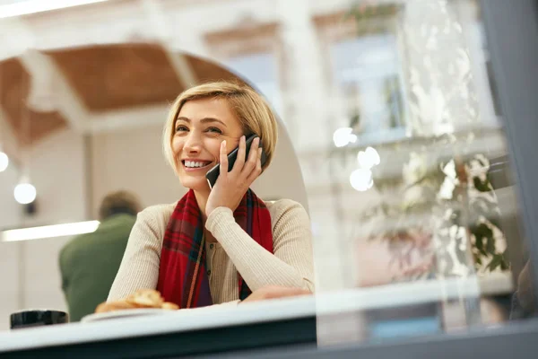 Mujer sonriente hablando por teléfono en el café — Foto de Stock