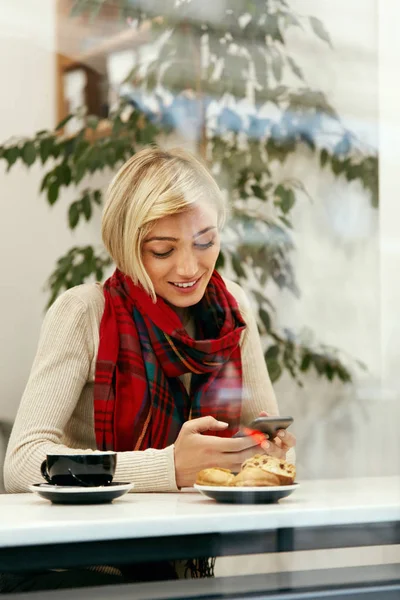 幸福的女人，在咖啡馆里使用手机 — 图库照片