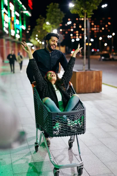 Pasangan sedang bersenang-senang di Shopping Mall Cart Outdoors In Evening — Stok Foto