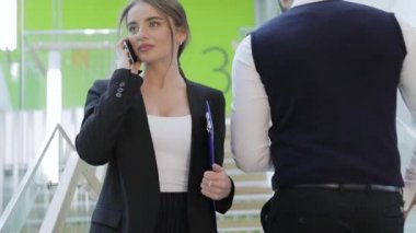 İş Merkezi. Kadın telefonu ofis binası içinde söz