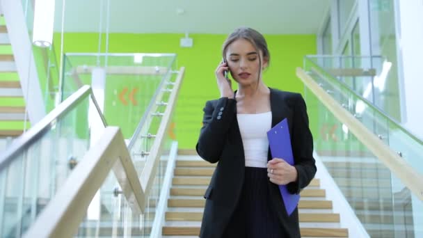Ligue. Mulher de negócios conversando no telefone móvel no centro de escritórios — Vídeo de Stock