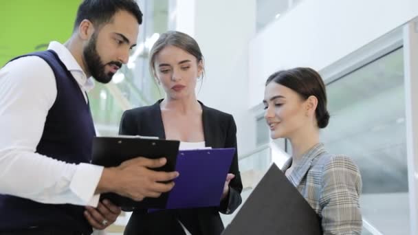 A mappák beszél a lépcsőn Office Center üzletemberek — Stock videók