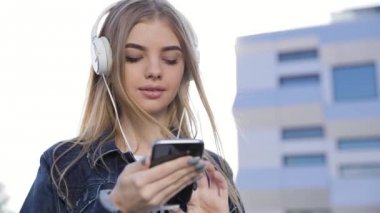 Açık havada telefonda müzik kulaklık güzel kadın