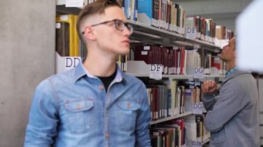 Öğrenci Kütüphanesi'nde. Adam Raflardan kitapları arıyorum