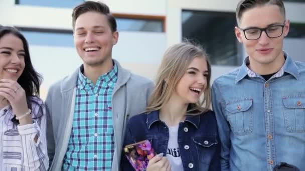 Gelukkige jonge mensen lopen op straat en praten — Stockvideo