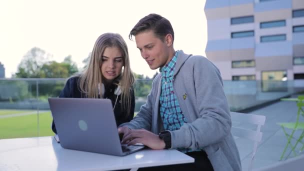 Jovem homem e mulher trabalhando no computador ao ar livre — Vídeo de Stock