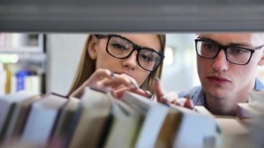 Öğrencilerin öğrenme raflardan kitap arama Kütüphane