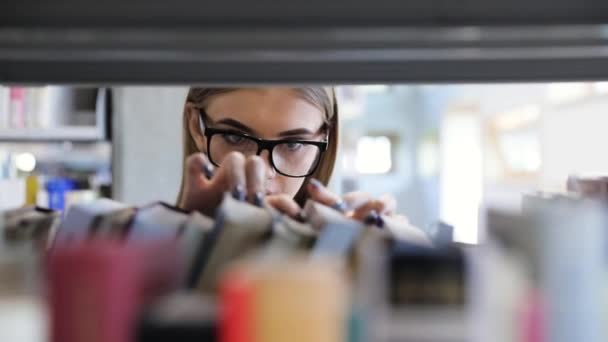 Boekhandel. Vrouw op zoek naar onderwijs boek op plank — Stockvideo