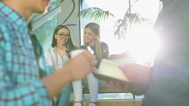 Estudiantes estudiando, leyendo notas en el libro en las escaleras de la universidad — Vídeo de stock