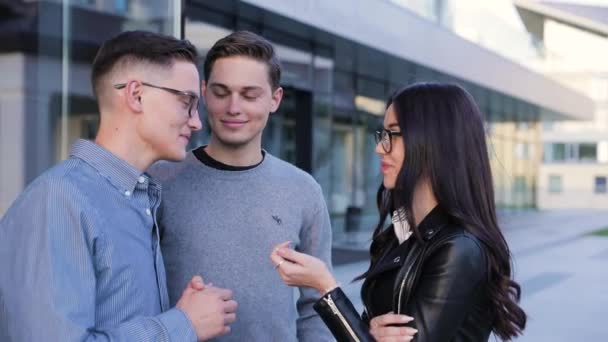 Молоді люди, що говорять на вулиці біля будівлі коледж — стокове відео