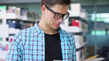 Kitabevi. Adam öğrenci okuma kitapları raflardan yakınındaki