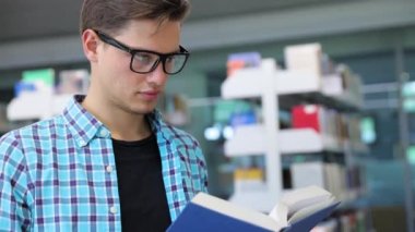 Kitabevi. Adam öğrenci okuma kitapları raflardan yakınındaki