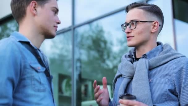 Les jeunes hommes parlent près de l'immeuble de bureaux — Video