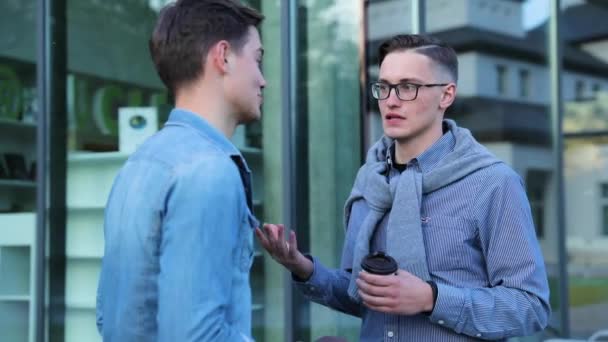 Unga män talar nära kontorsbyggnad utomhus — Stockvideo