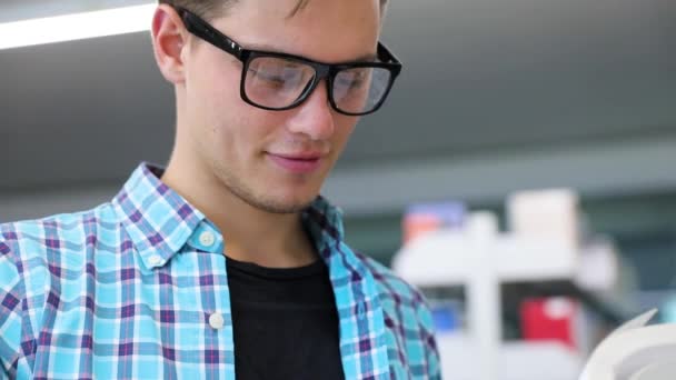 Librería. Hombre Estudiante leyendo libros cerca de librerías — Vídeos de Stock