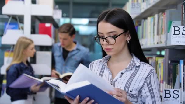 Knihovny. Usmívající se žena čtení knih u Poličky na univerzitě